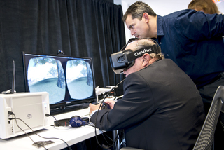 Robert Miron (left) and Dan Pacheco, Peter A. Horvitz Endowed Chair in Journalism Innovation (right), try out the oculus rift device in the newly renovated studios.