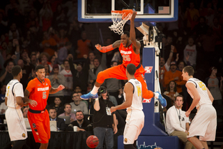 Syracuse center Rakeem Christmas hangs on the rim after throwing down an alley-oop dunk on Syracuse's first possession. 