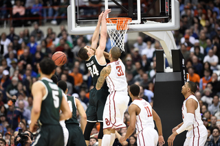 MSU's Gavin Schilling (34) grabs on to the rim after being blocked by OU's D.J. Bennett. 