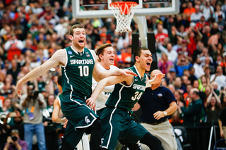 Michigan State's entire team runs onto the court as the game clock hits zero at the end of overtime.