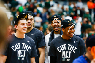The Spartans tie pieces of the net to the top of their hats as they are greeted by fans and family. 