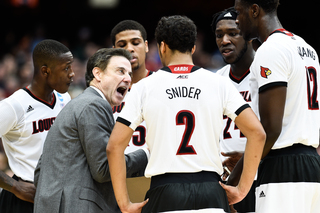Pitino yells to his team during a huddle.