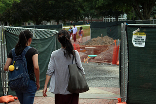 A couple Syracuse University community members navigate through the construction sites on the SU campus. Photo taken July 28, 2016