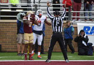 Ishmael celebrates a touchdown catch, a Boston College defender holds his hands on his head and a referee signals the call.